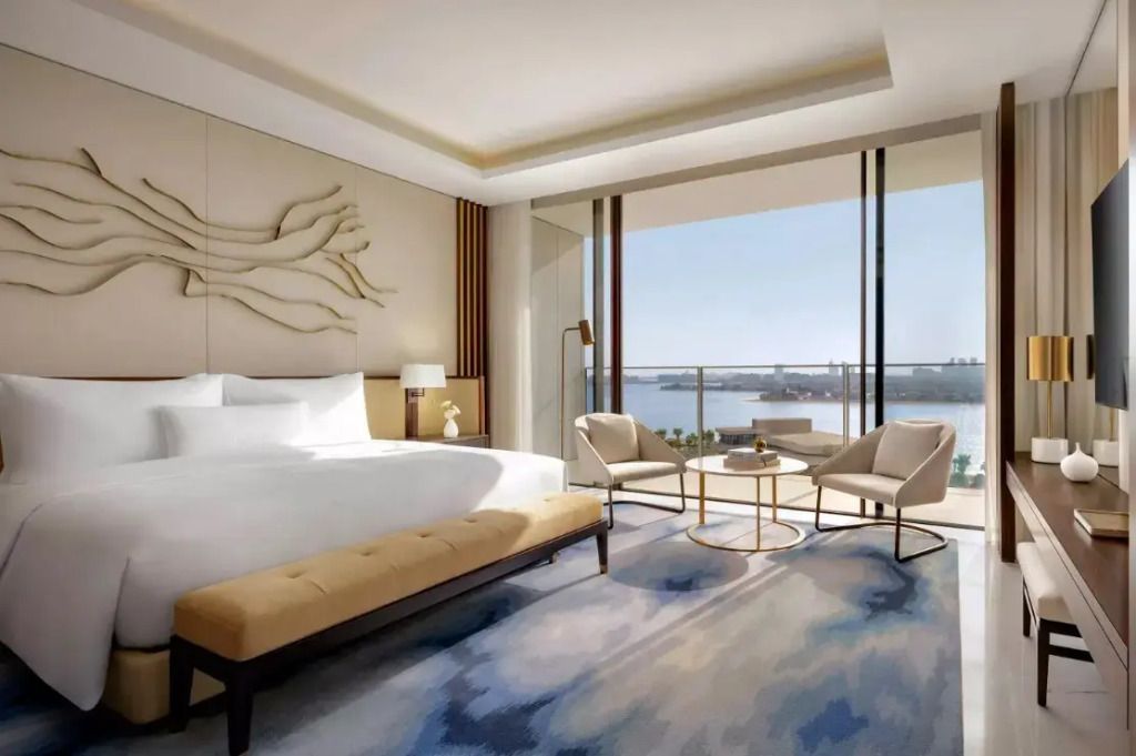 Helles Schlafzimmer in der Suite mit großer Fensterfront und Blick auf die Skyline