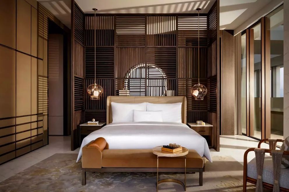 Luxuriöses Schlafzimmer mit modernen Holzelementen und eleganten Hängelampen.