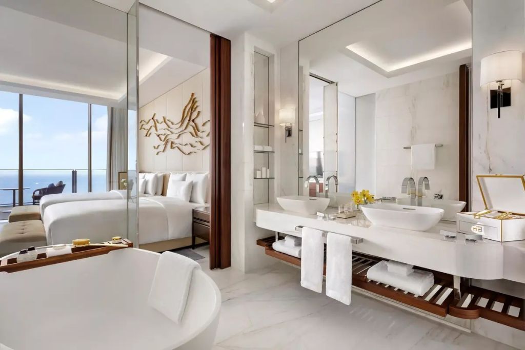 Großzügiges Badezimmer mit Badewanne und Blick ins Schlafzimmer