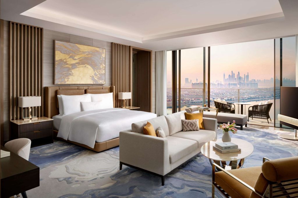 Luxuriöse Suite mit großem Bett, Sitzbereich und Aussicht auf Skyline im Atlantis The Royal Palm Jumeirah.