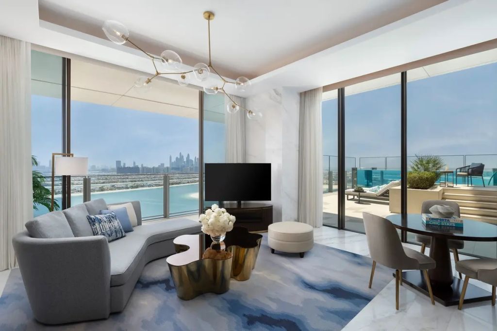 Helles Wohnzimmer mit großer Fensterfront und Blick auf das Meer