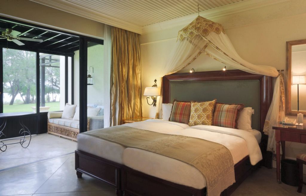 Deluxe Zimmer mit elegantem Doppelbett und einem Balkon mit Blick ins Grüne