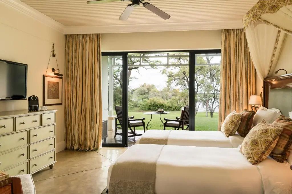Deluxe Zimmer mit zwei Einzelbetten, großer Fensterfront und Gartenblick