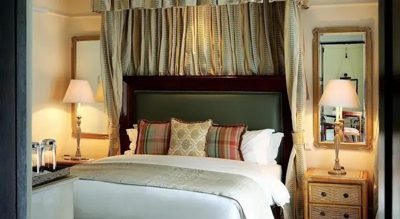 Luxus Doppelbett mit eleganten Kissen und Vorhängen im Hotelzimmer