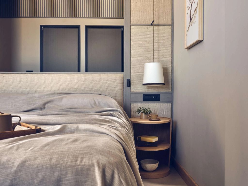Gemütliches Doppelbett im Deluxe Zimmer mit stilvollem Nachttisch und Wandkunst