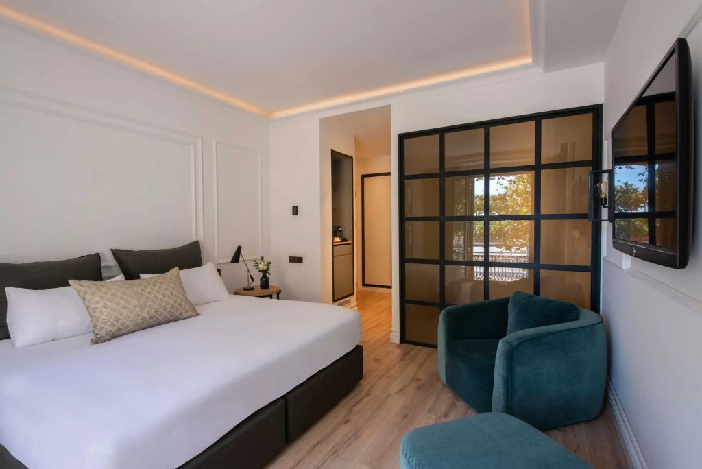 Deluxe Zimmer mit großem Doppelbett und stilvollen Möbeln in modernen Farbtönen