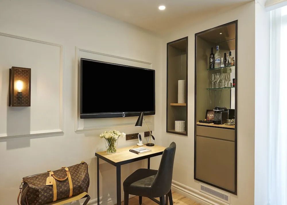 Arbeitsbereich mit Flachbildfernseher und Minibar im stilvollen Hotelzimmer