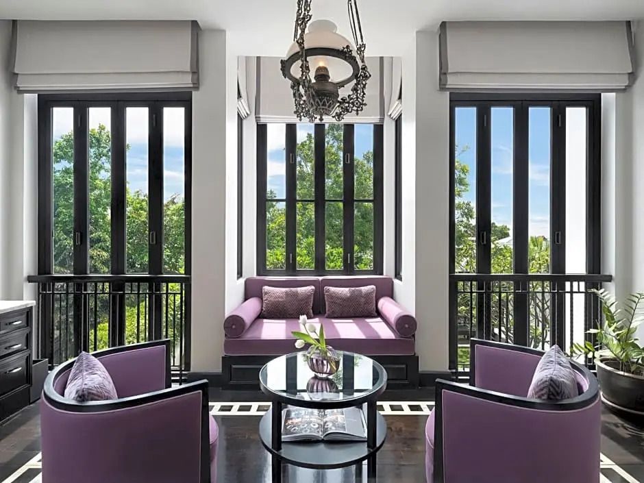 Elegantes Wohnzimmer mit großen Fenstern und lila Sofas