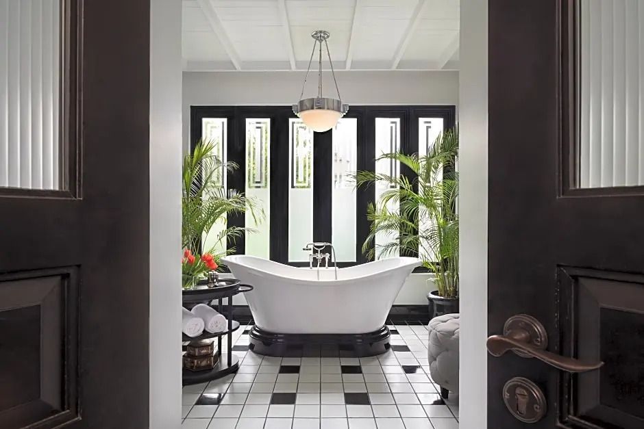 Luxuriöses Badezimmer mit freistehender Badewanne und üppigem Pflanzenarrangement.