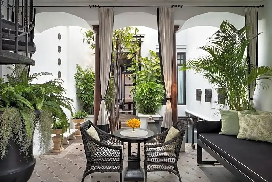 Überdachte Terrasse mit elegantem Sitzbereich und viel Grün