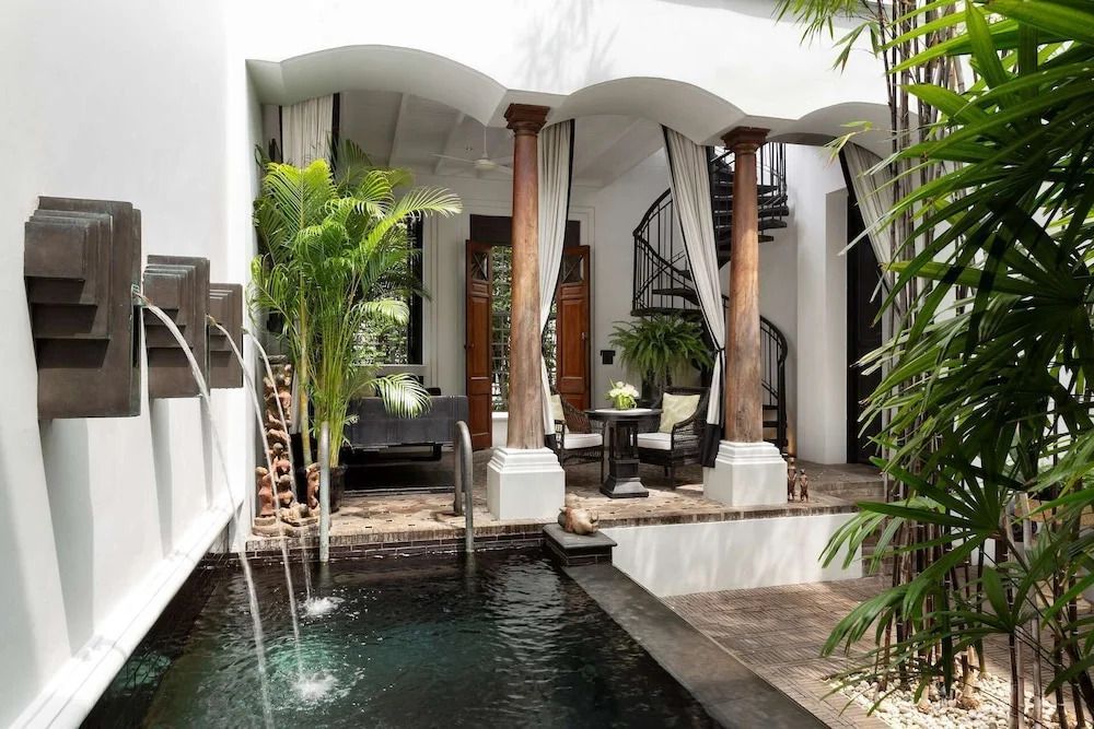 Luxuriöse private Terrasse mit Pool und spiralförmiger Treppe, umgeben von Pflanzen