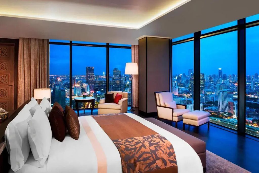Luxuriöses Schlafzimmer mit Panoramafenstern und Blick auf Bangkoks Skyline bei Nacht
