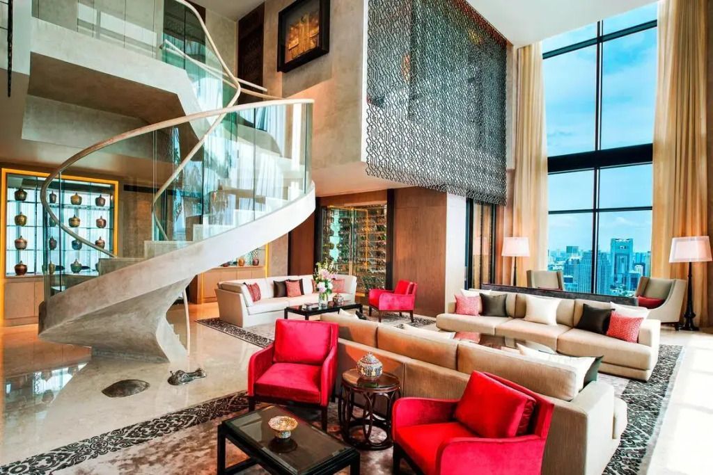 Elegantes Wohnzimmer mit Wendeltreppe und modernen Möbeln in warmen Farbtönen