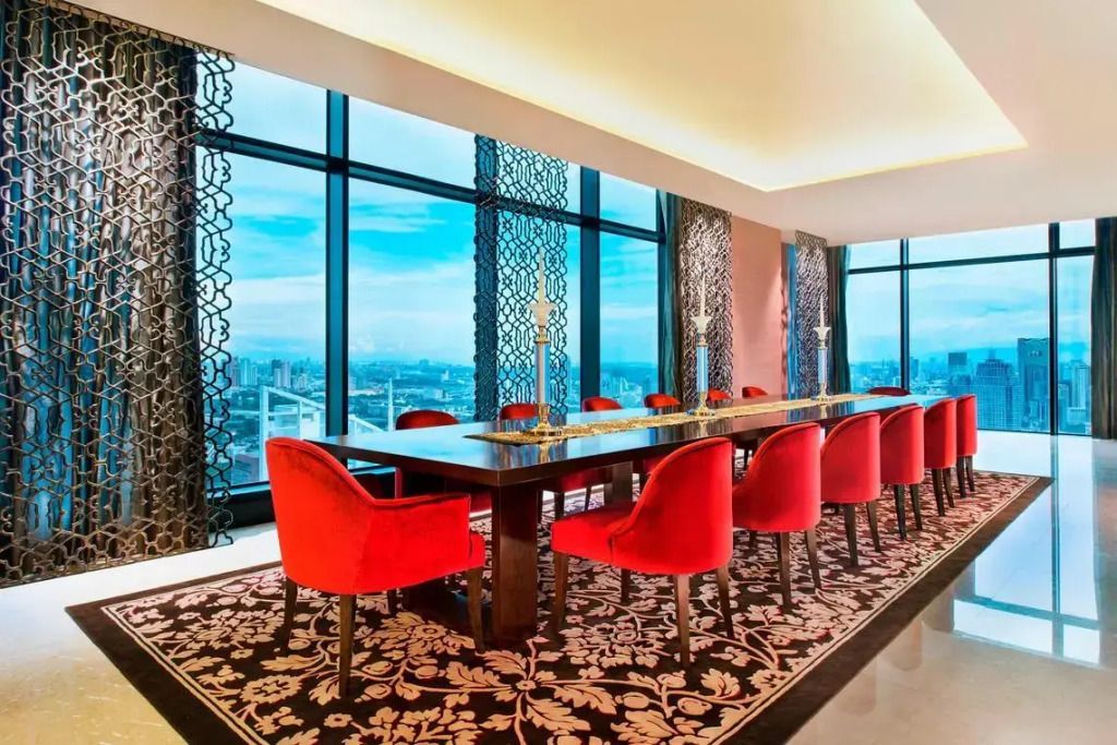 Esszimmer mit großem Tisch und roten Stühlen vor Panoramafenster in Bangkok