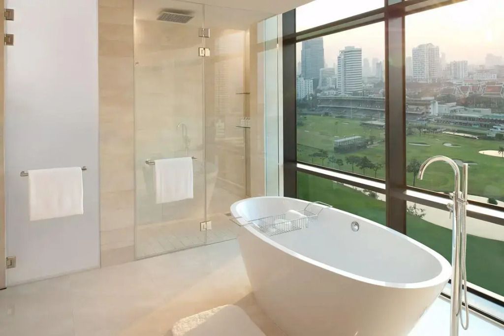 Luxuriöses Badezimmer mit freistehender Badewanne und Stadtblick.