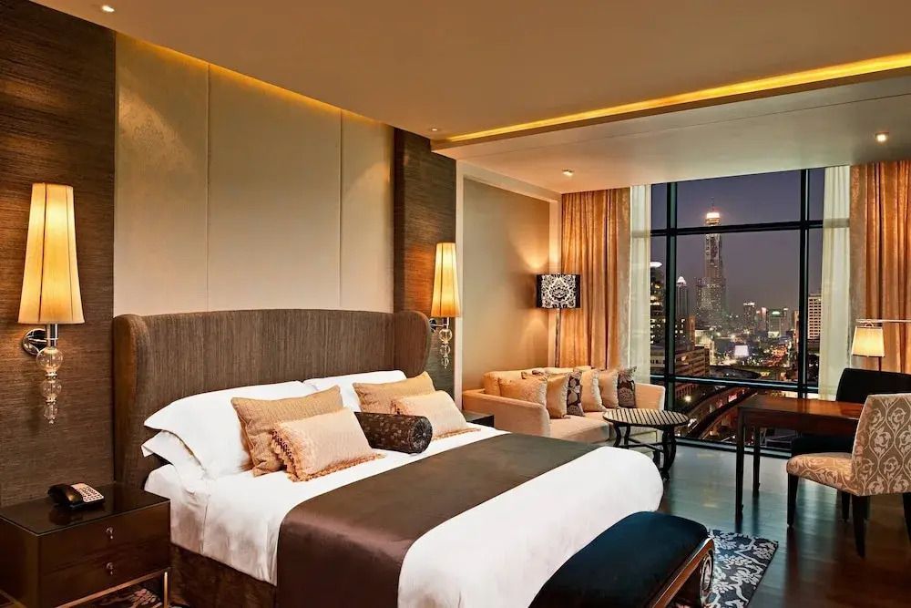 Hochwertig eingerichtetes Zimmer mit stimmungsvollem Abendlicht und Stadtblick