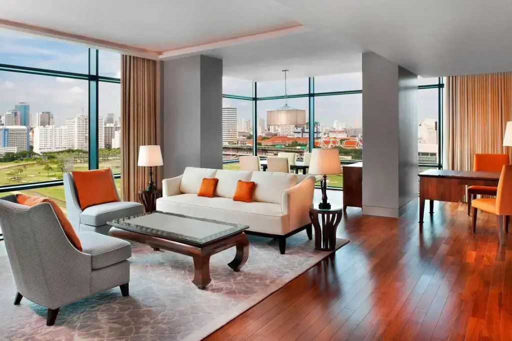 Geräumiges Wohnzimmer der Suite mit modernen Möbeln und großen Fenstern