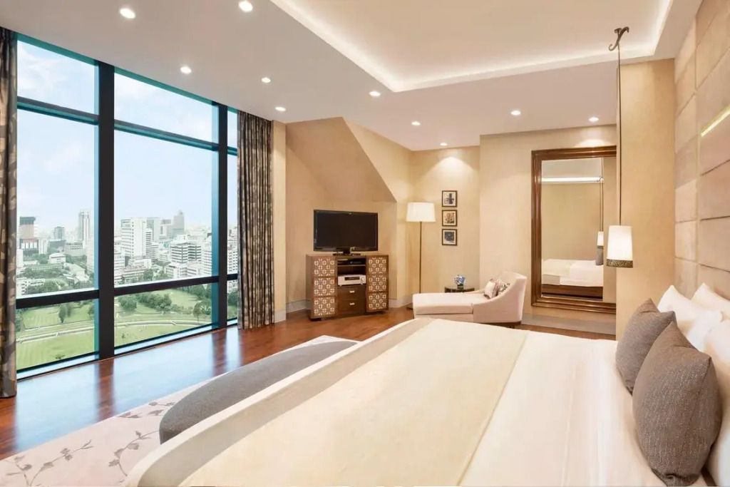 Luxuriöse Suite mit großem Bett und Blick auf Golfplatz und Stadt