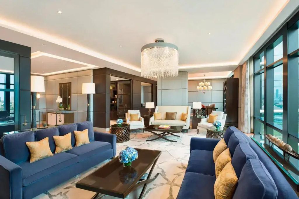 Geräumige Lounge mit blauen Sofas und luxuriöser Beleuchtung