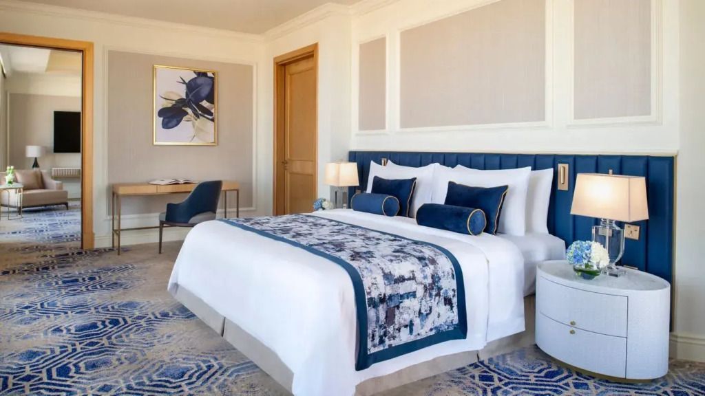 Helles Doppelzimmer mit königblauen Akzenten und modernem Kunstwerk