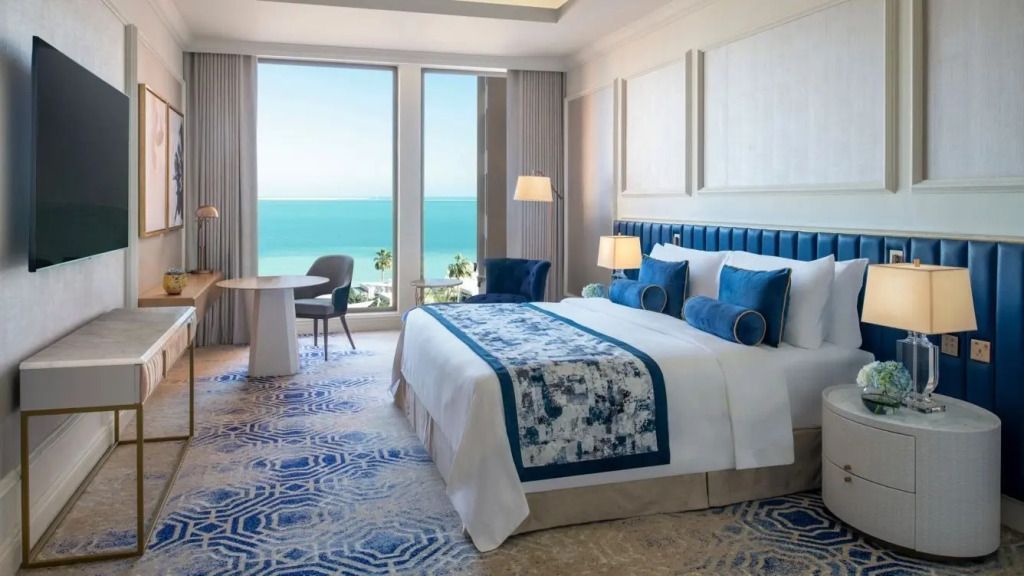 Luxuriöses Zimmer mit Doppelbett und Meerblick durch große Fenster