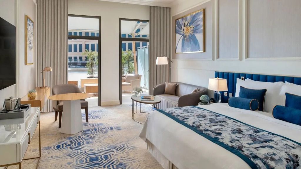 Suite mit Sitzecke und Zugang zur Terrasse mit Poolblick