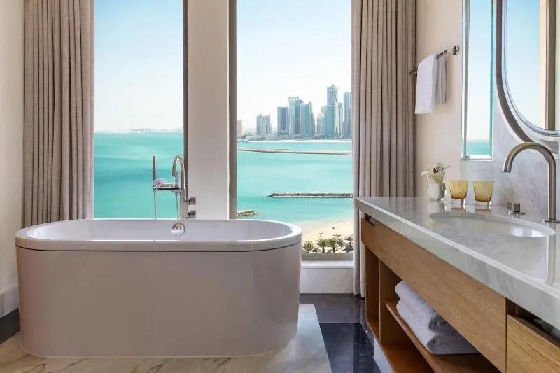 Badezimmer mit freistehender Badewanne und Aussicht auf das Meer