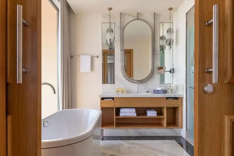 Modernes Badezimmer mit freistehender Badewanne und großen Spiegeln