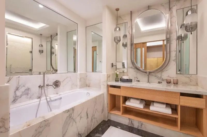 Badezimmer mit Badewanne und eleganter Marmorverkleidung
