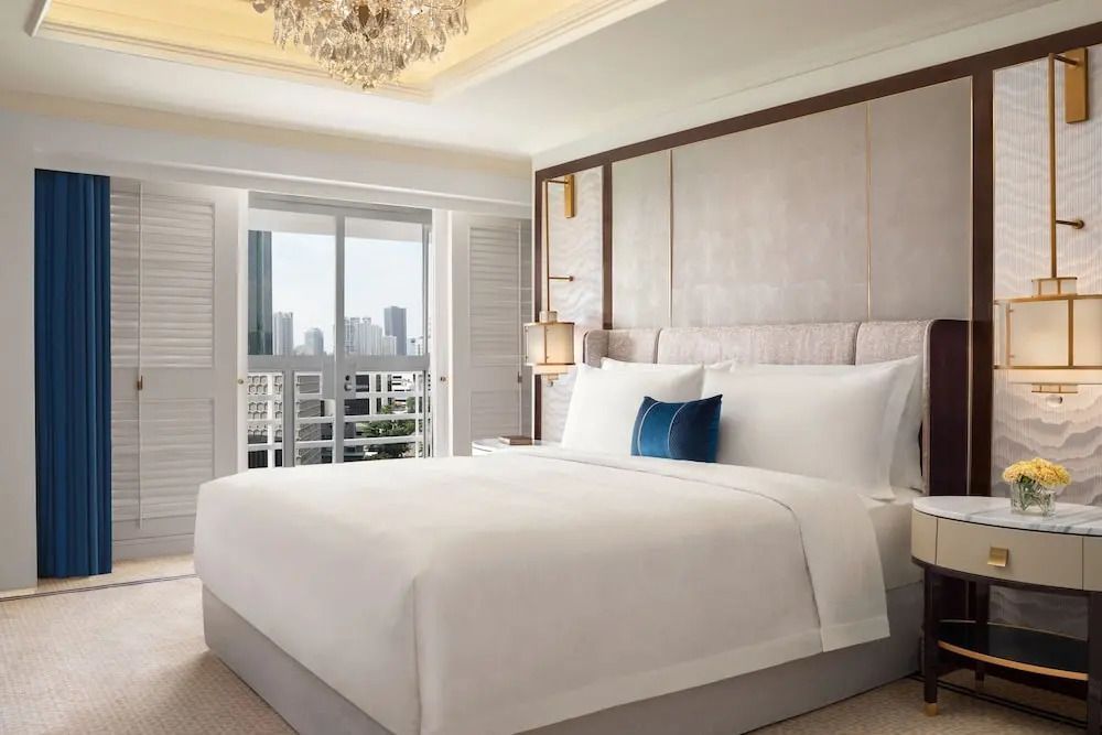 Geräumiges Schlafzimmer mit großem Bett und urbaner Aussicht vom Balkon in Jakarta
