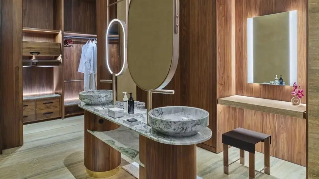 Modernes Badezimmer mit zwei runden Waschbecken aus Marmor und ovalem Spiegel