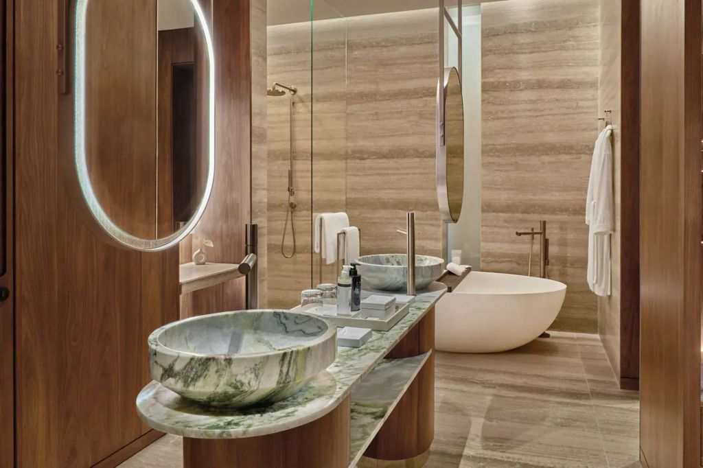 Luxuriöses Bad mit Marmorwaschbecken und freistehender Badewanne
