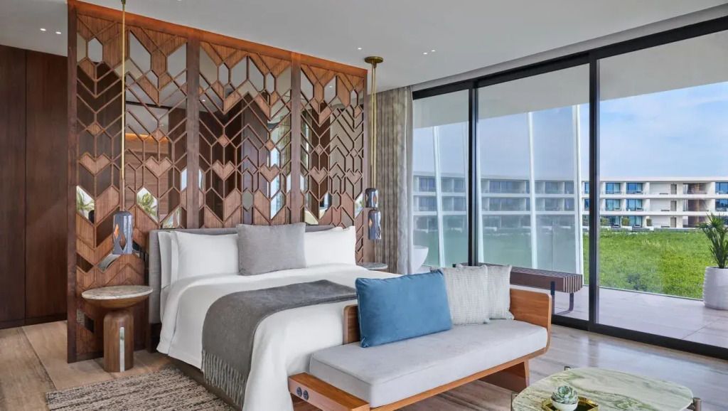 Luxuriöse Suite mit Doppelbett, Holzverkleidung und großen Fenstern mit Ausblick.