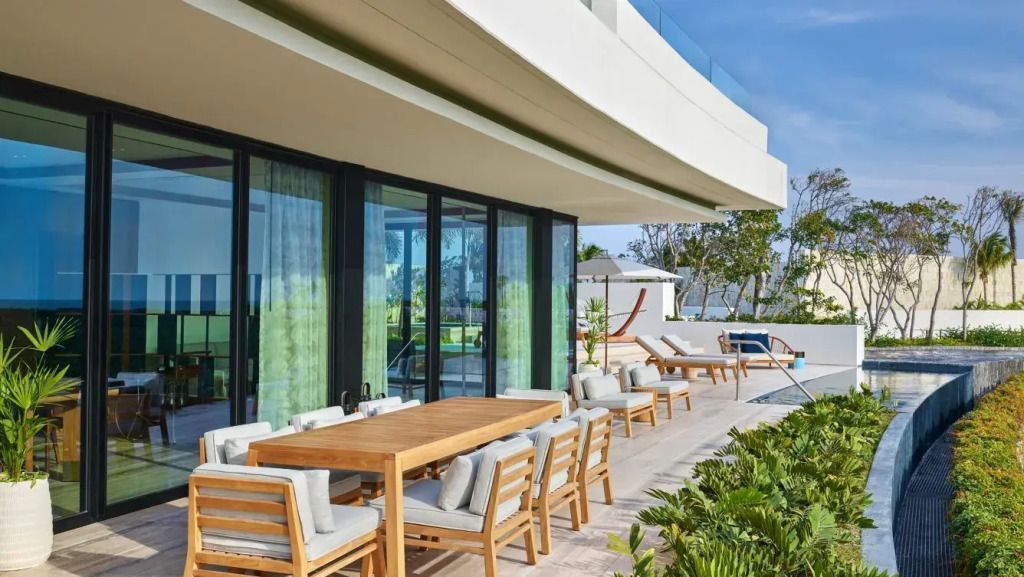 Große Terrasse mit Esstisch und Blick auf die Gartenlandschaft.