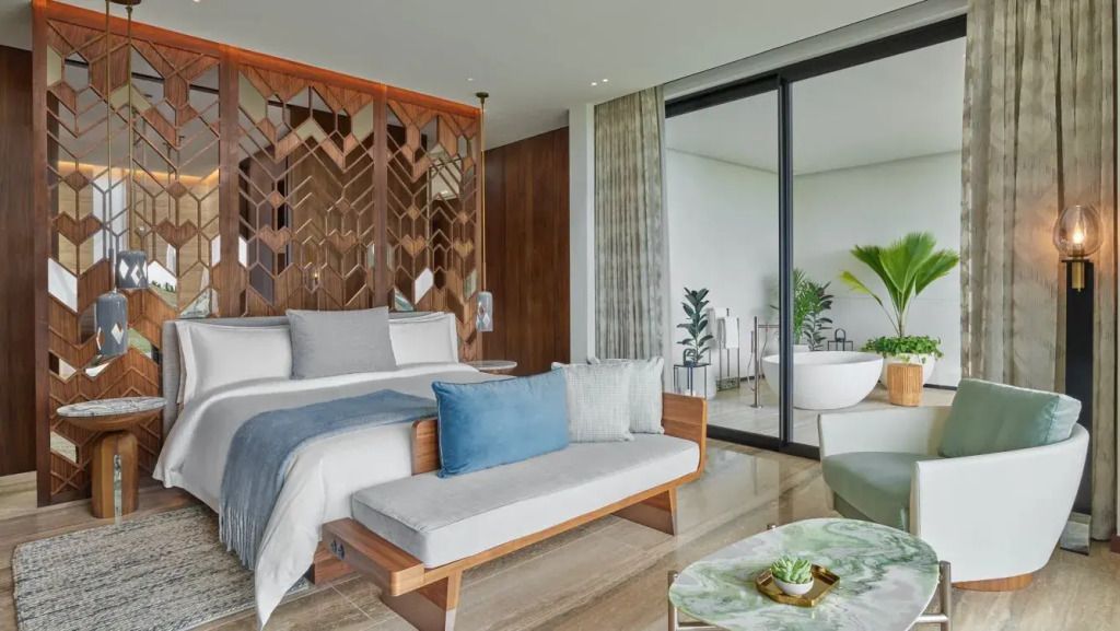 Elegantes Doppelzimmer mit modernen Holzelementen und Blick ins Badezimmer