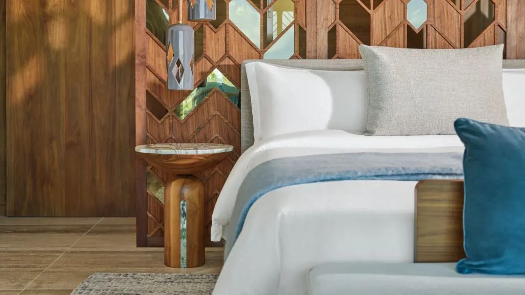 Schlafzimmerdetail mit Holzverkleidung und Designer-Tischlampe neben dem Bett.