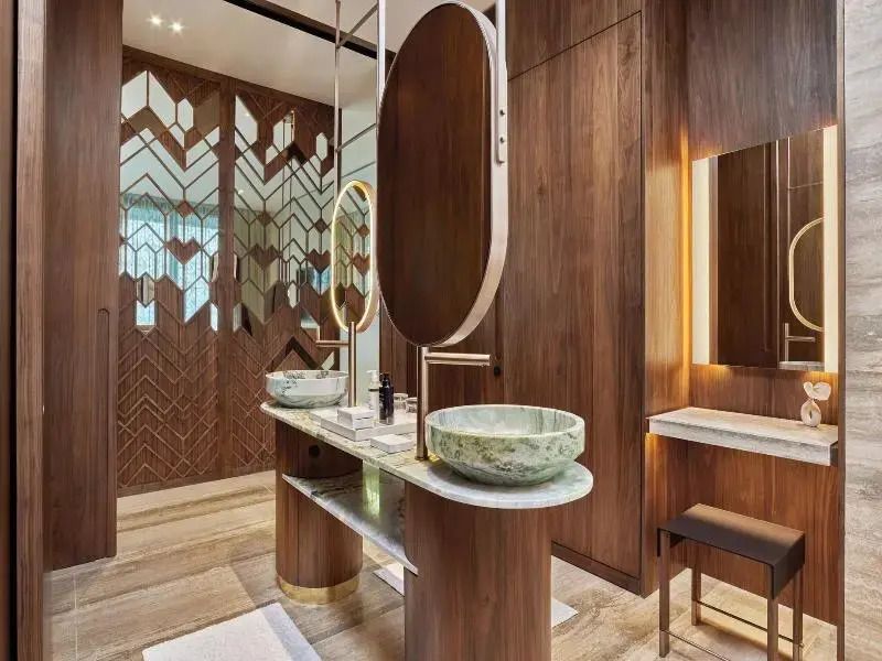 Luxuriöses Badezimmer mit grünen Waschbecken und Holzdetails