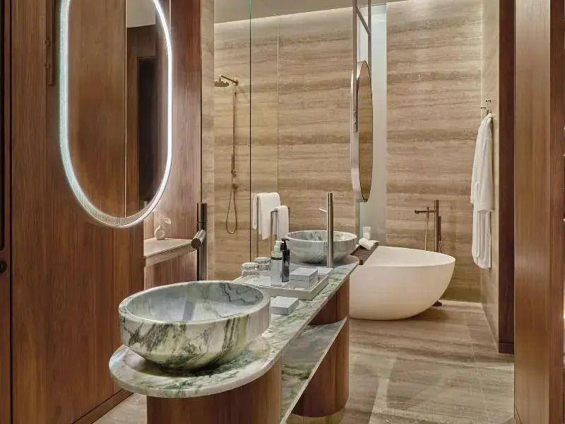 Modernes Badezimmer mit Doppelwaschbecken und freistehender Badewanne aus Marmor