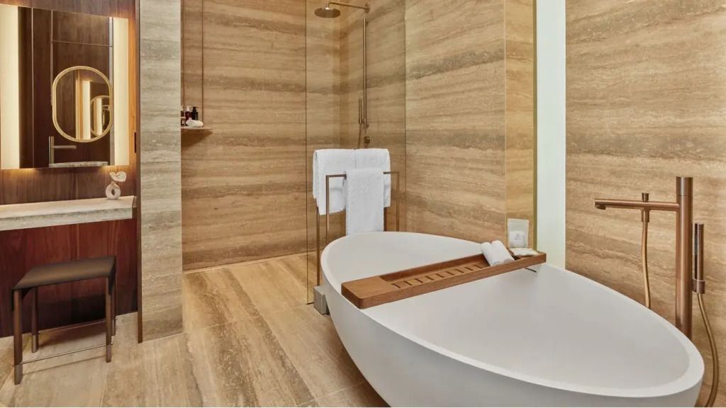 Badezimmer mit freistehender Badewanne und eleganter Dusche, holzverkleidet