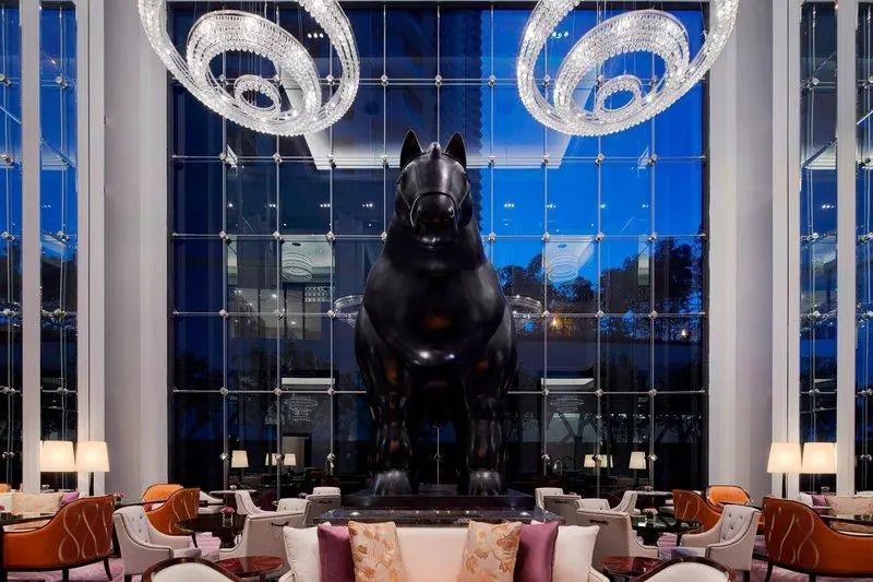 Elegante Hotellobby mit großer Pferdestatue und modernen Kronleuchtern