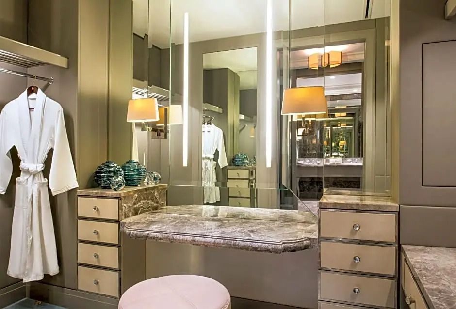 Eleganter Schminktisch mit Marmorplatte und warmem Licht in der Suite