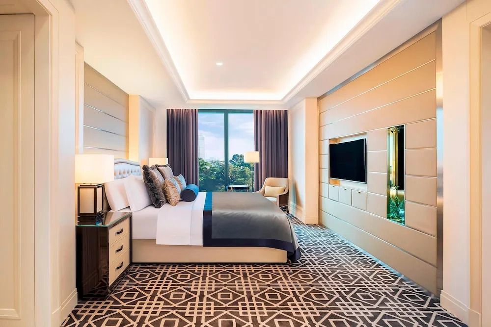 Helles Schlafzimmer mit Flachbildfernseher und großem Fenster