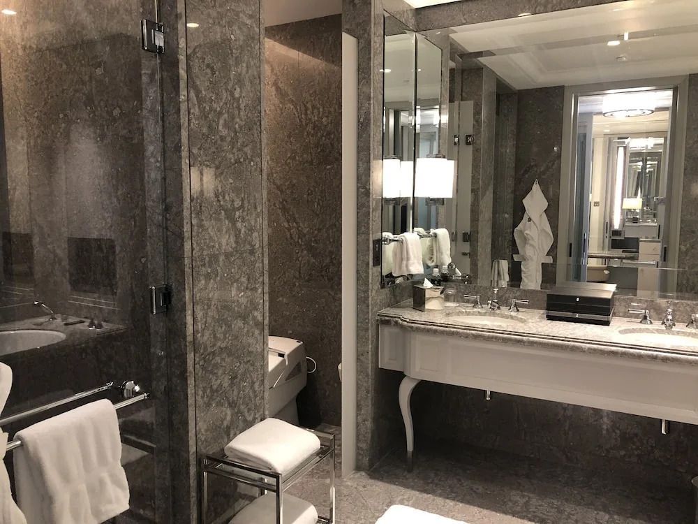 Luxuriöses Badezimmer mit edlen Marmorwänden und einem eleganten Waschtisch.