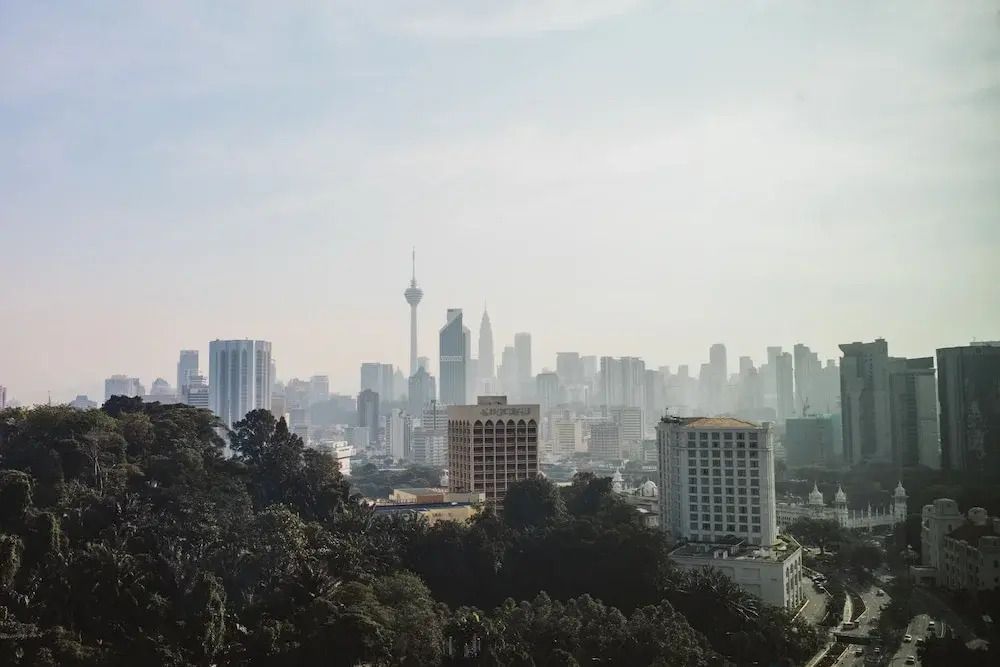 Panoramablick auf Kuala Lumpurs Skyline mit berühmten Gebäuden und grünem Vordergrund