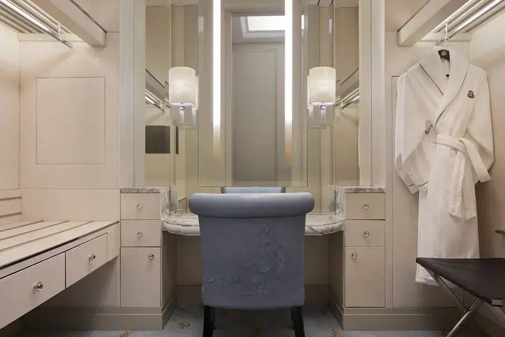 Stilvolles Badezimmer mit beleuchtetem Spiegel und eleganter Sitzgelegenheit