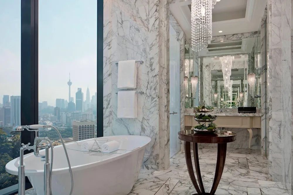 Luxuriöses Badezimmer mit freistehender Badewanne und Aussicht auf die Stadt