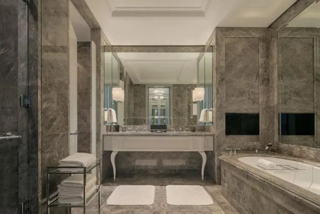 Modernes Badezimmer mit Marmorverkleidung und großen Spiegeln