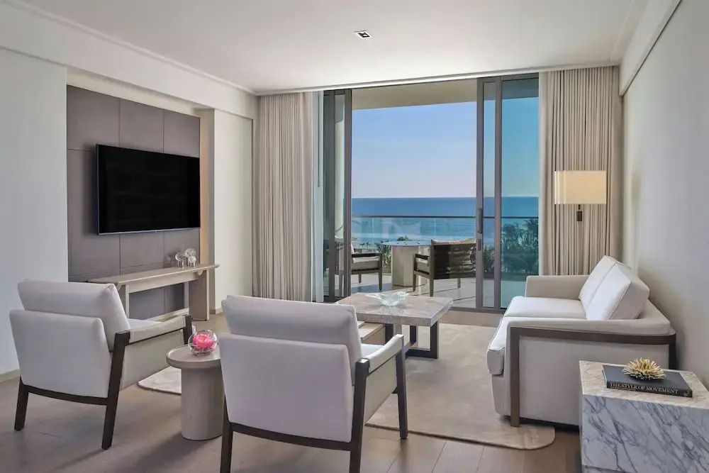 Eleganter Wohnraum mit Blick auf das Meer durch große Fenster.