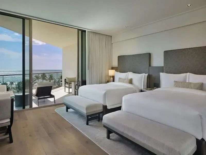 Elegantes Hotelzimmer mit zwei Doppelbetten und Balkon mit Meerblick