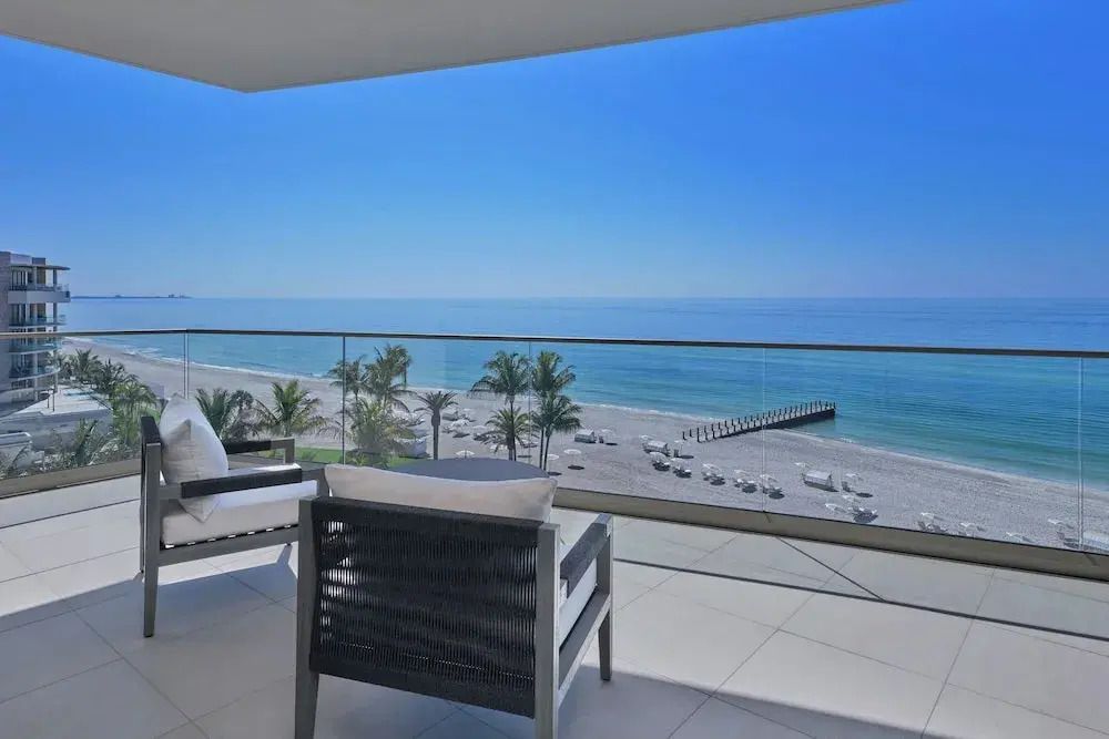 Moderner Balkon mit Blick auf den Strand und das Meer. Klare, blaue Himmel.